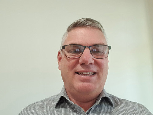 Self portrait of Shane Wilkinson wearing glasses, and collared shirt.