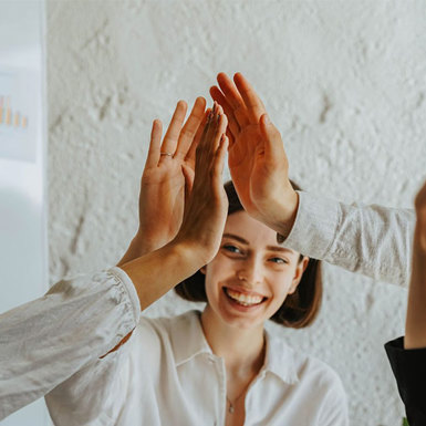 Female student high-fiving fellow students