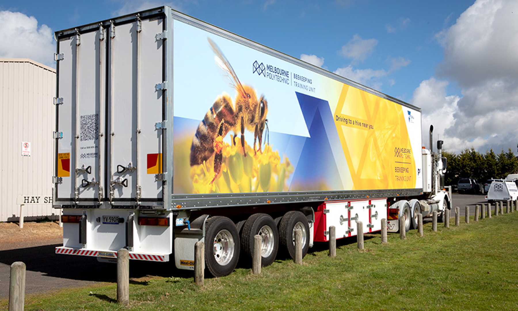 A large truck with "Melbourne Polytechnic Beekeeping Training Unit" and an image of a bee printed on the side.