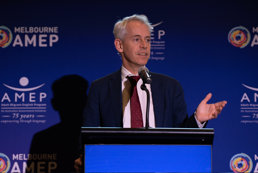 Hon. Andrew Giles MP, Federal Minister for Scullin and Minister for Immigration, Citizenship and Multicultural Affairs, on stage speaking at the AMEP 75-year anniversary event.