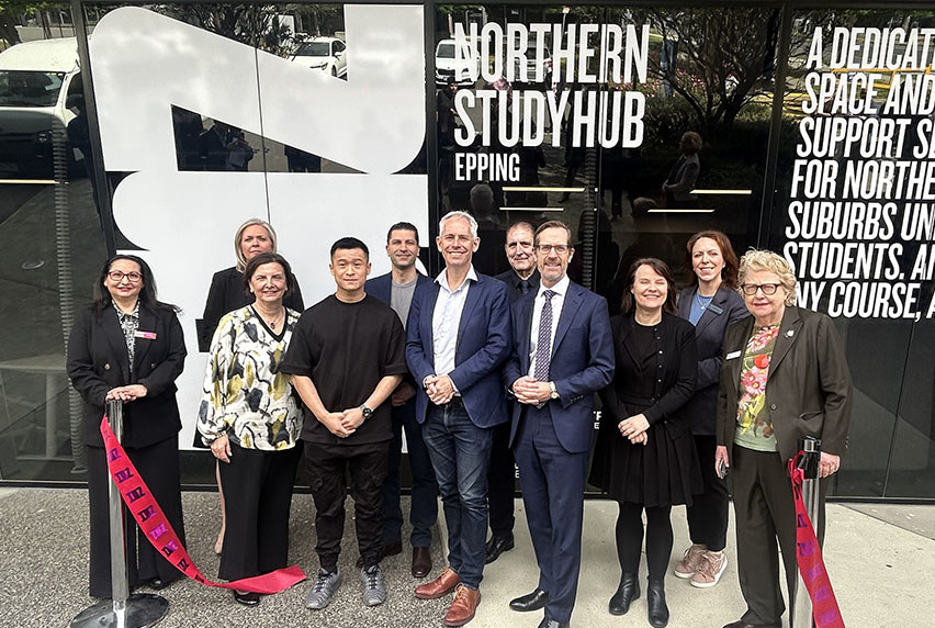 People standing in front of a building. The window says Northern Study Hub Epping.