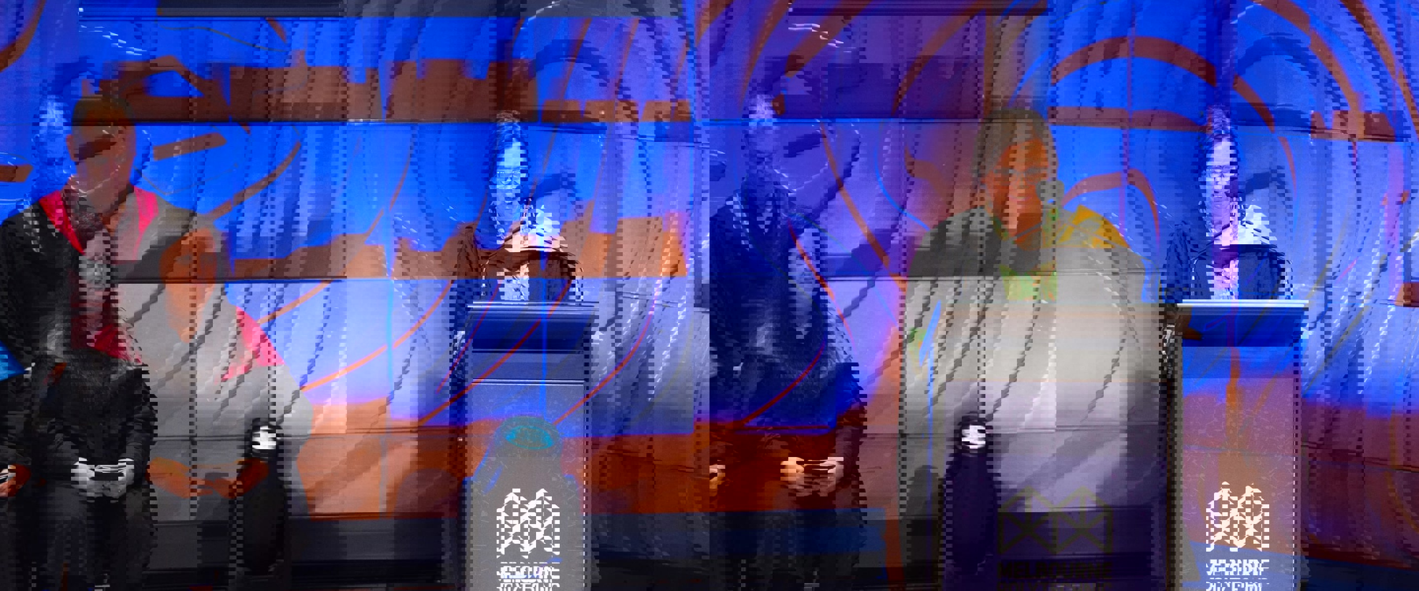 Frances Coppolillo standing at a Melbourne Polytechnic–branded lectern for graduation ceremony.