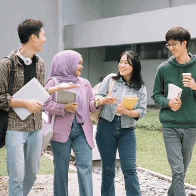 Group of university students walks and talks together outdoors on campus during a break