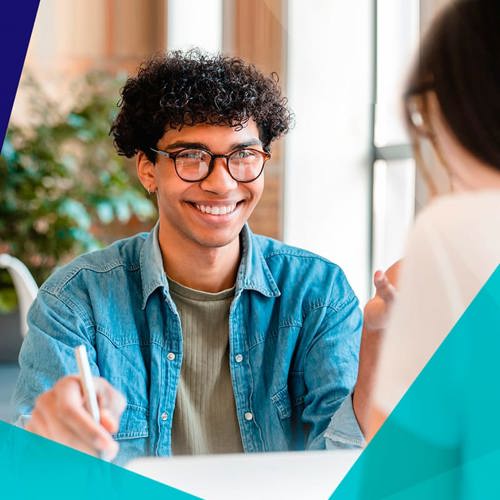 Smiling young student speaking with a career counsellor at a desk